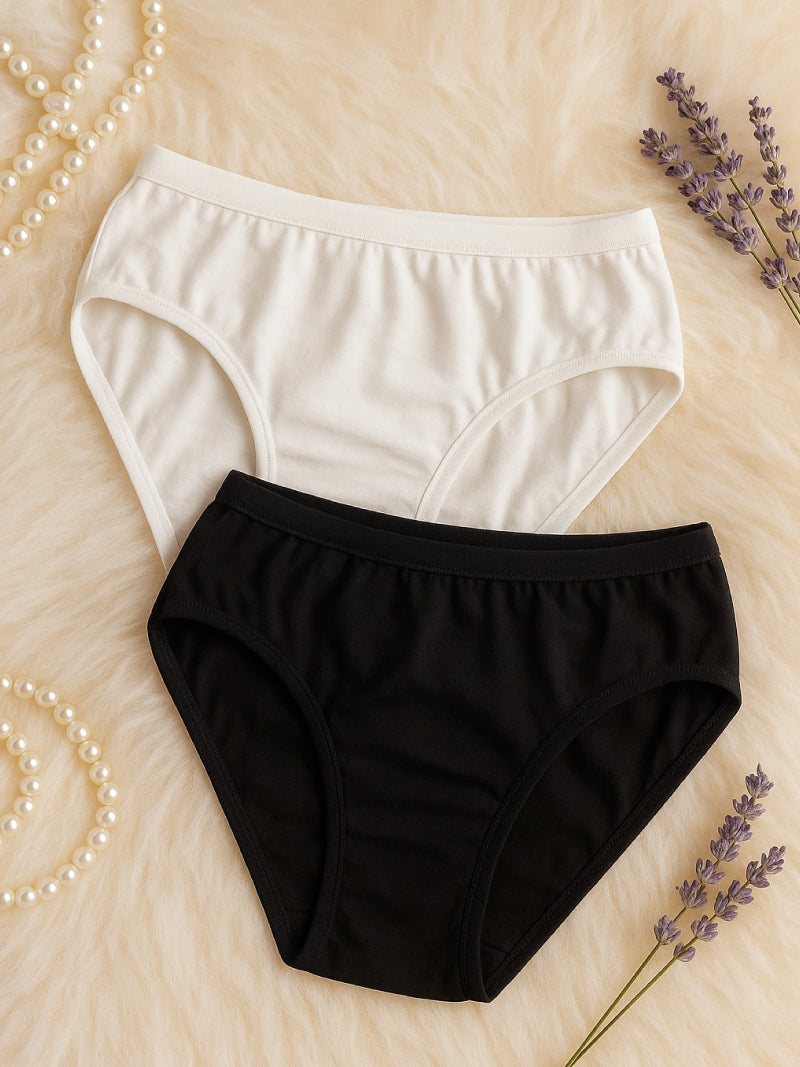 White and black underwear on a beige surface with lavender flowers.
