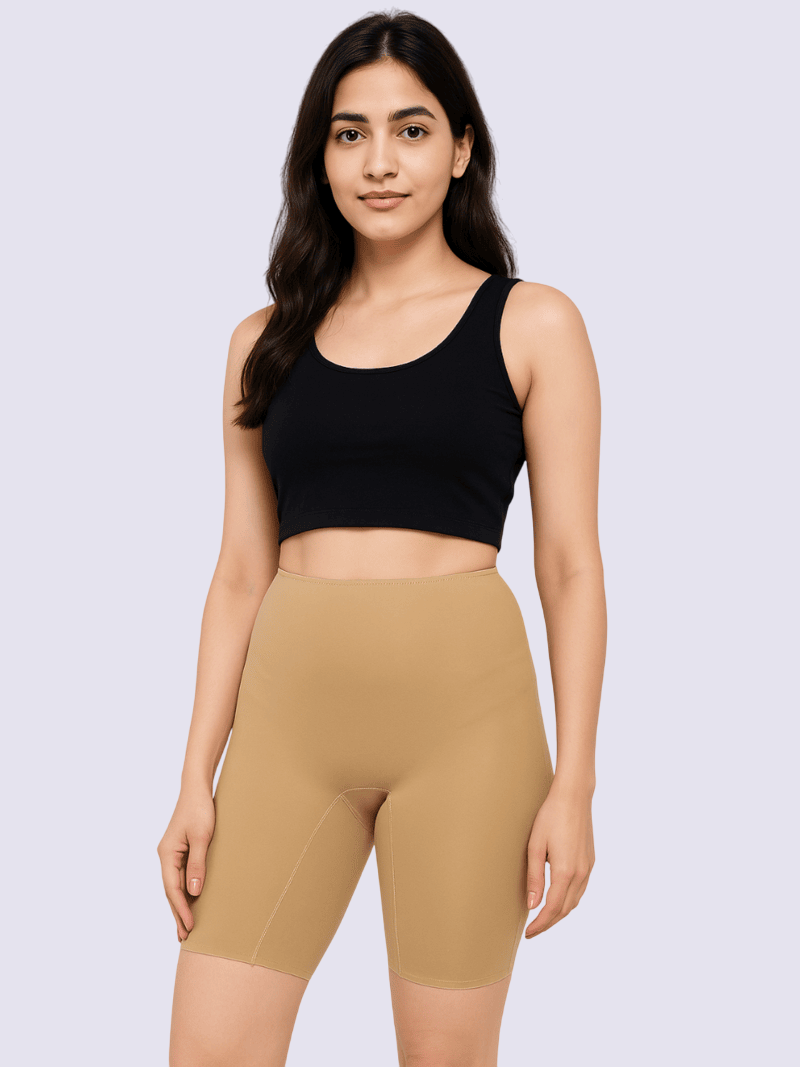 Woman wearing a black crop top and beige shorts on a light purple background