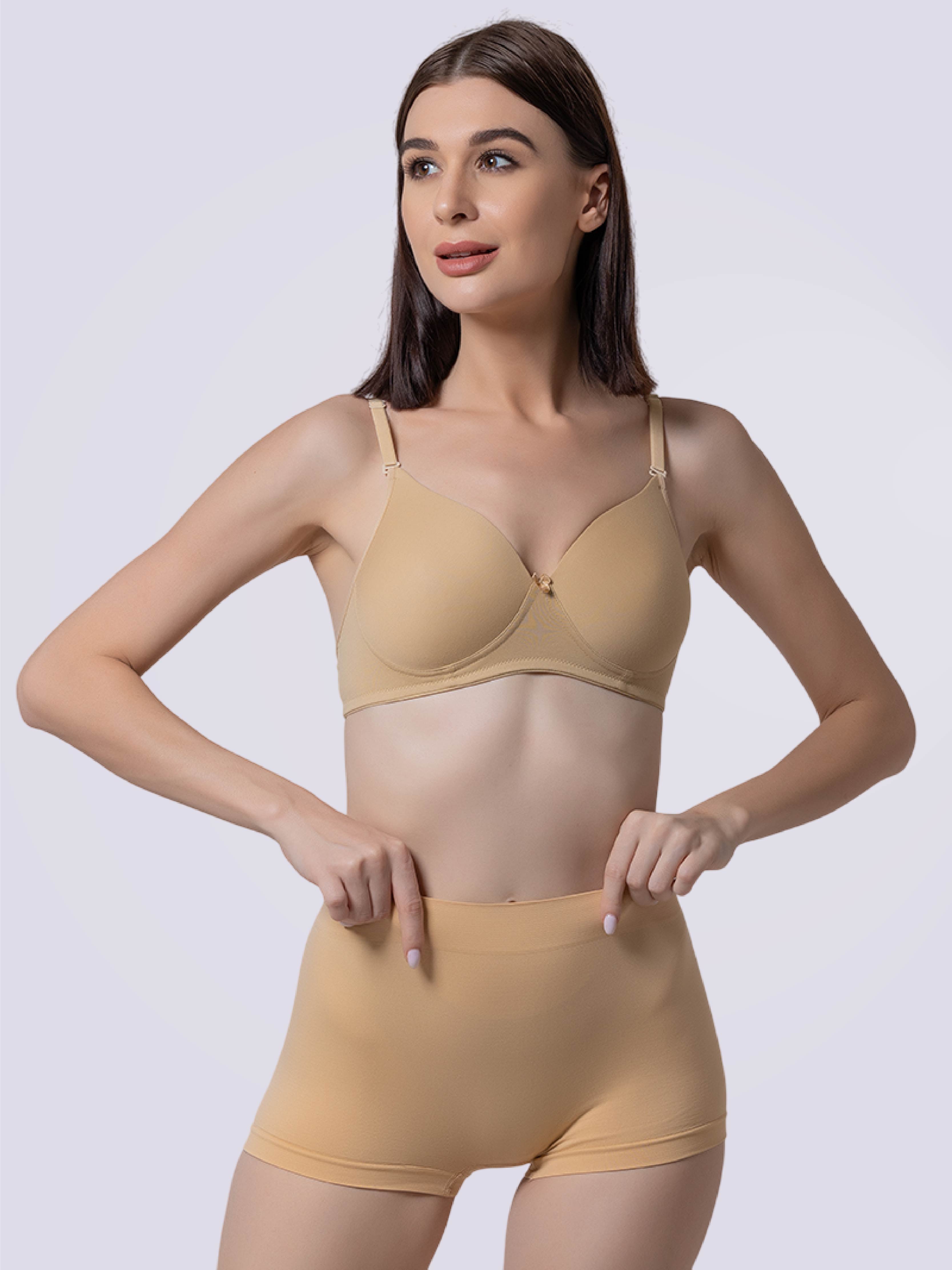 This image features a model showcasing a pair of mid-waist, full coverage boy-short panties in white, paired with a matching bra in a subtle brown shade. The panties are designed to provide maximum comfort and coverage, making them ideal for wearing under tight-fitting or body-hugging garments like gym tights, pencil skirts, or bodycon dresses.