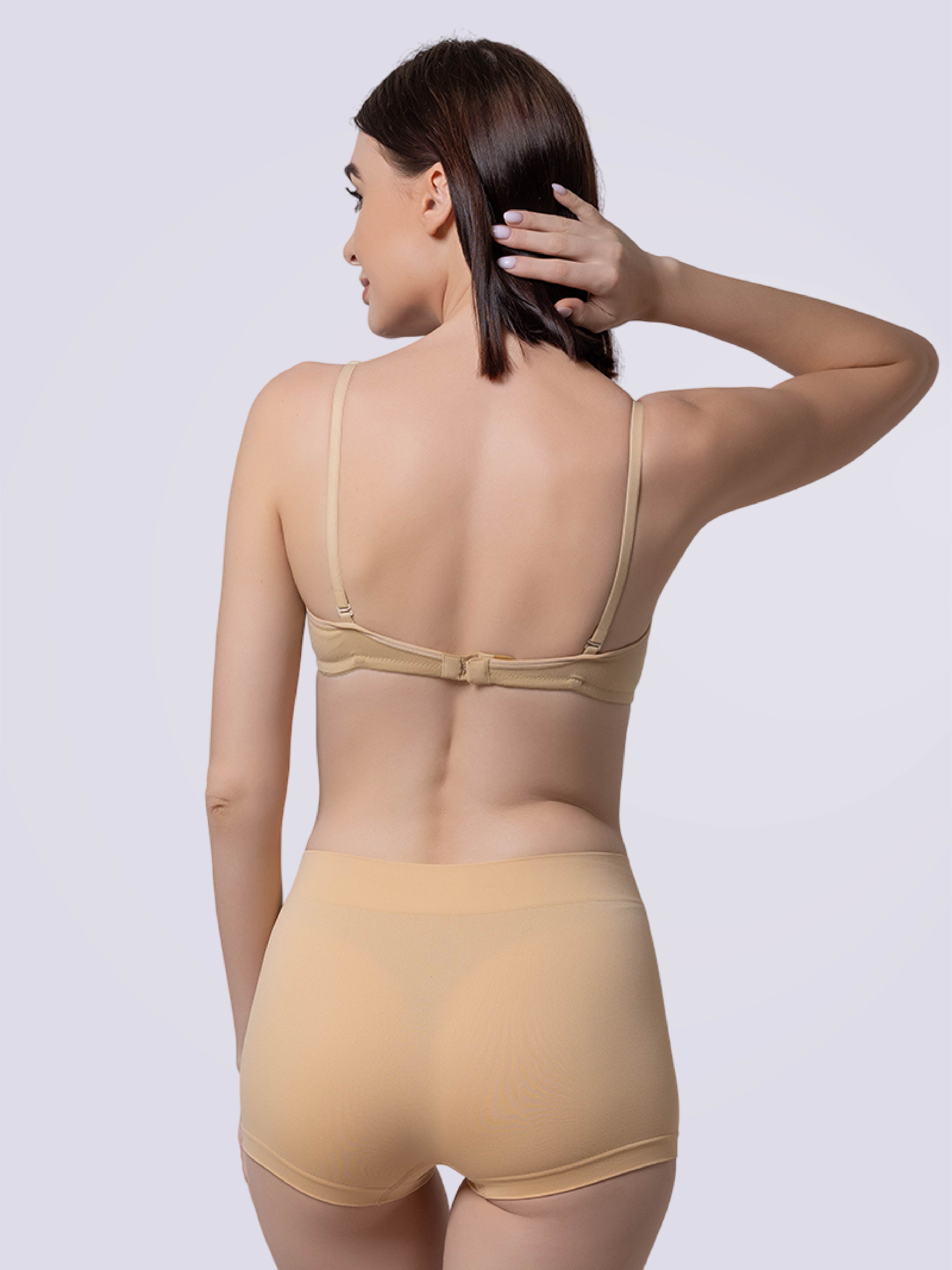 Woman wearing a beige bra and panties set from the back.