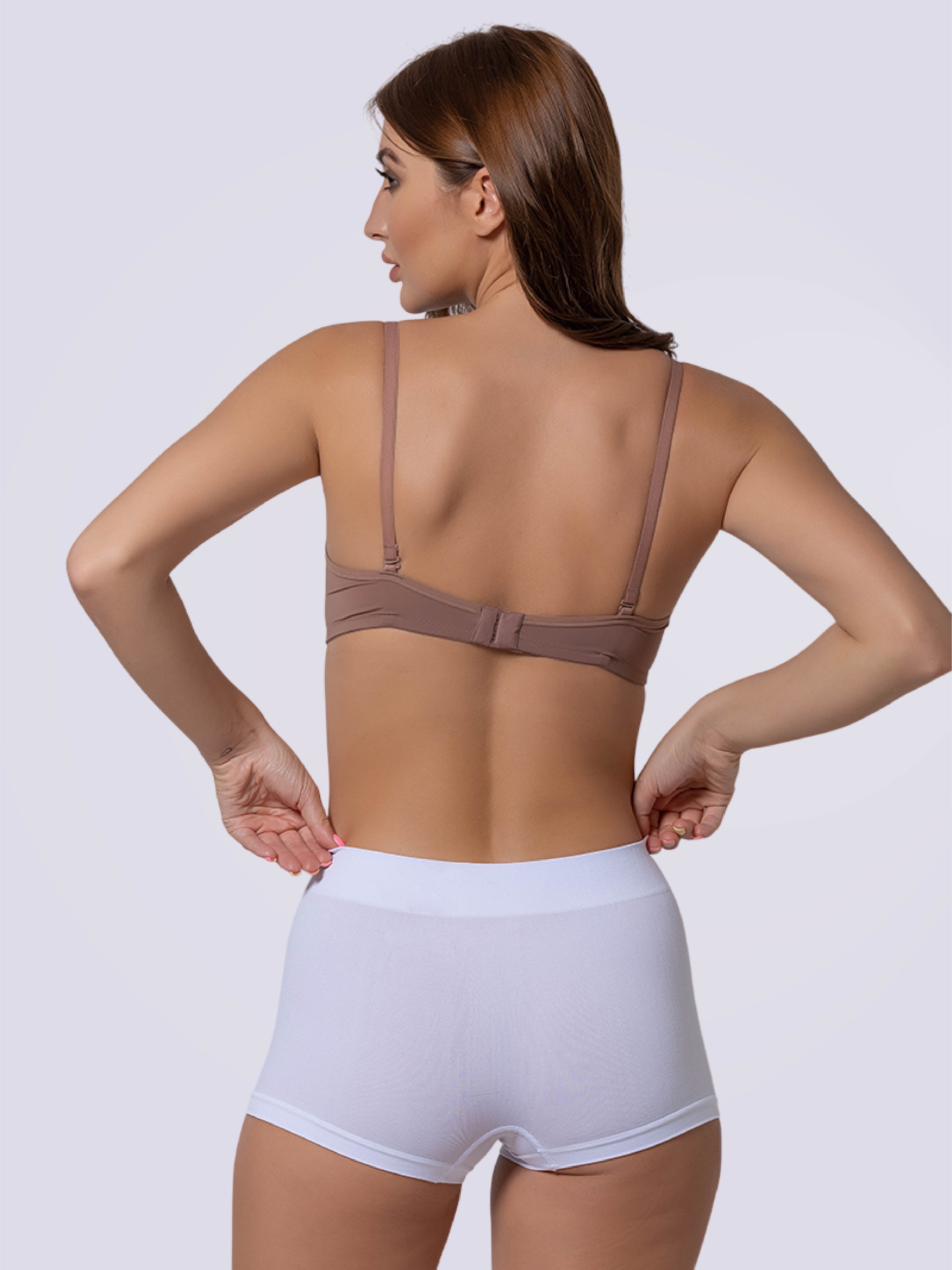 Woman wearing a brown bra and white shorts on a plain background