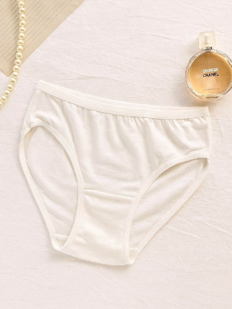 Beige underwear and a Chanel perfume bottle on a light background