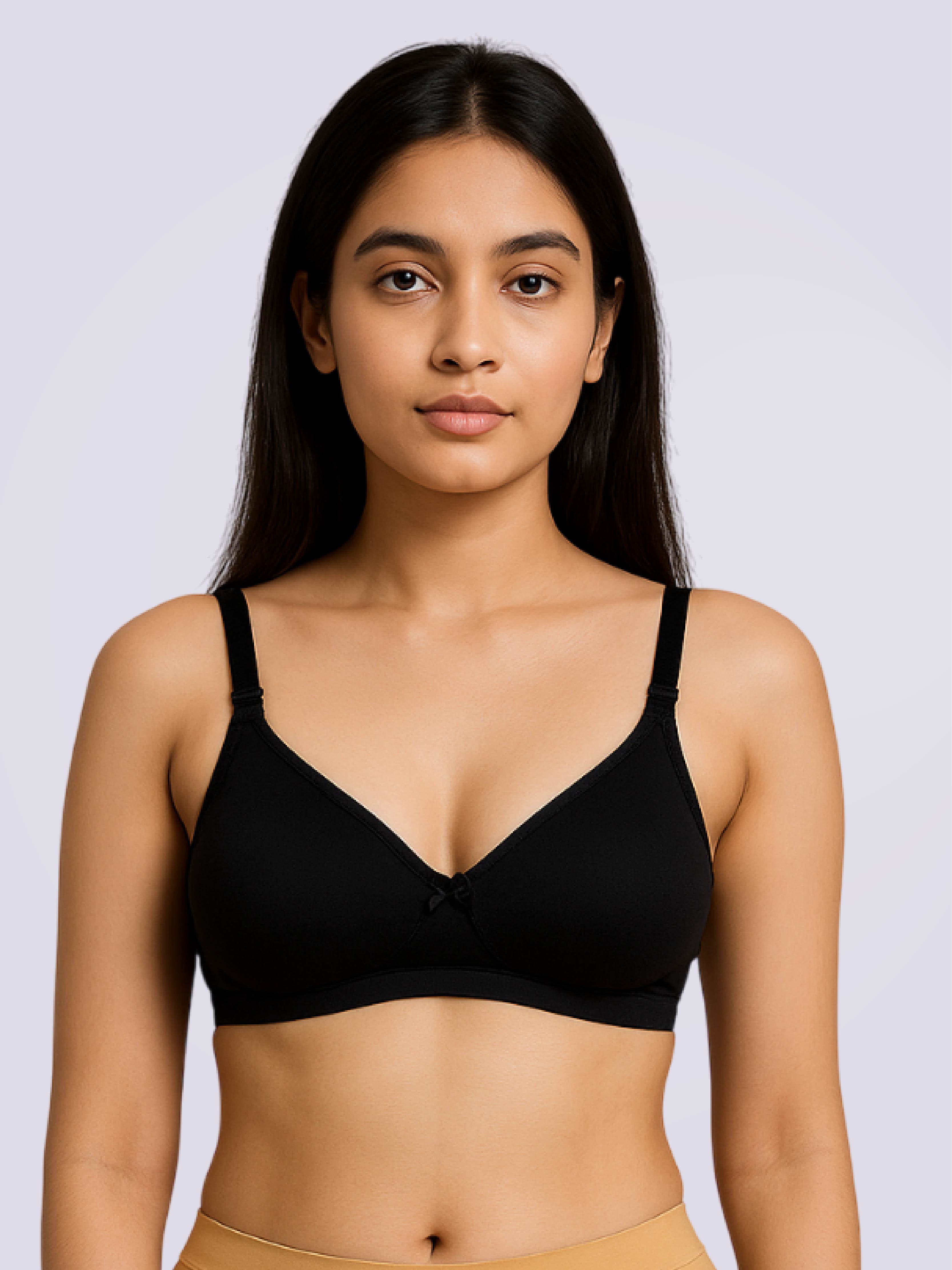 Woman wearing a black bralette against a plain background
