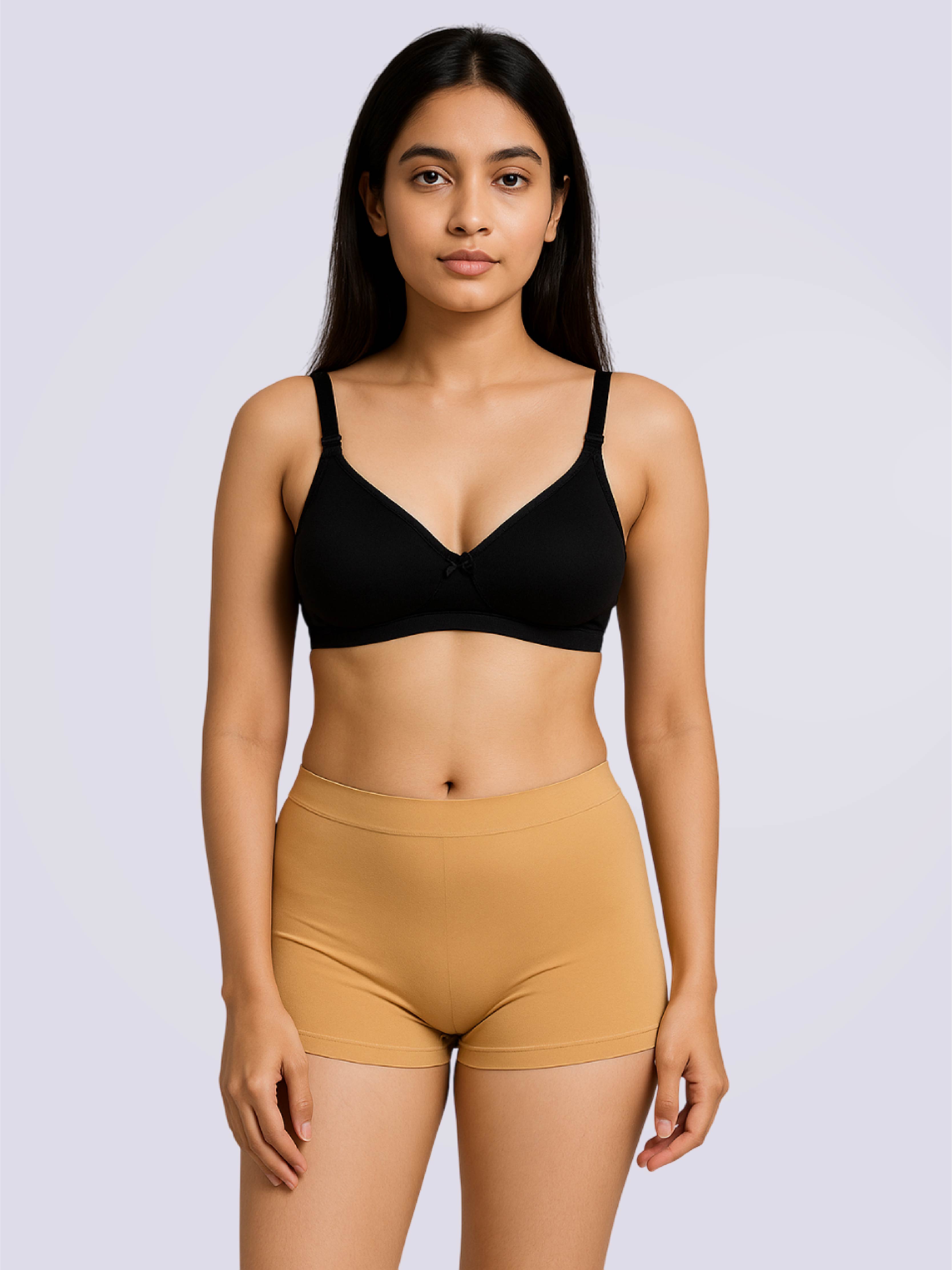 Woman wearing a black bra and mustard shorts on a light purple background