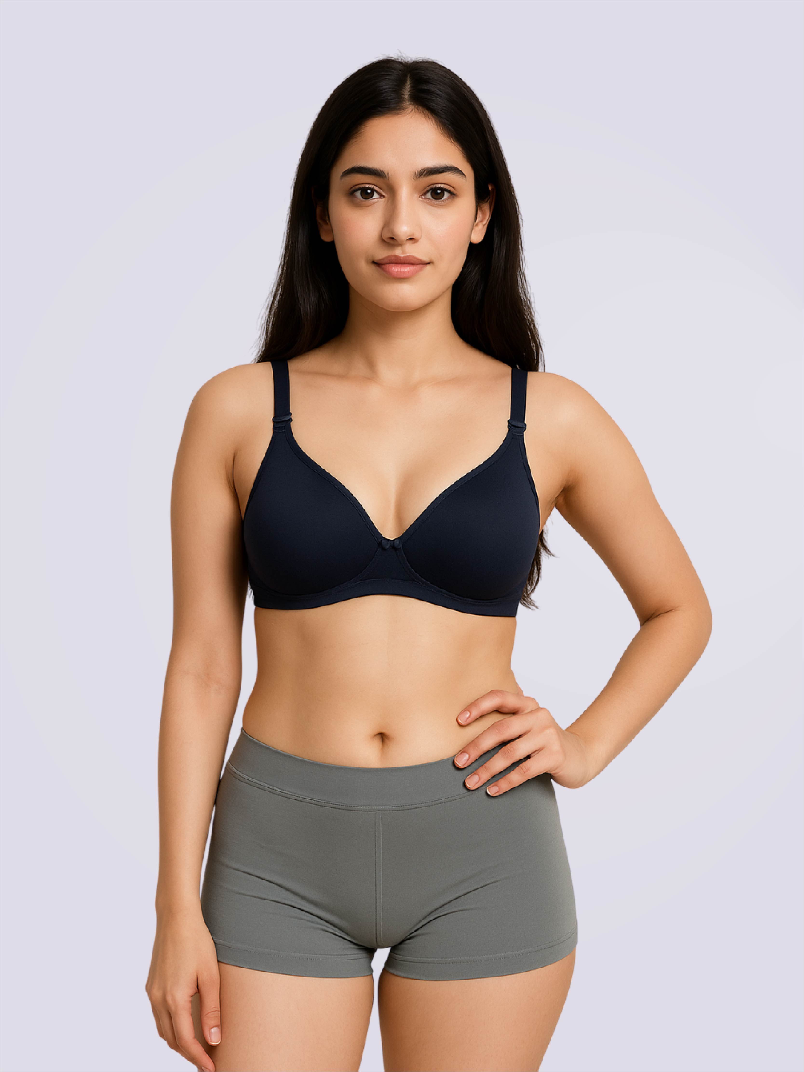 Woman wearing a blue bra and gray shorts on a light purple background