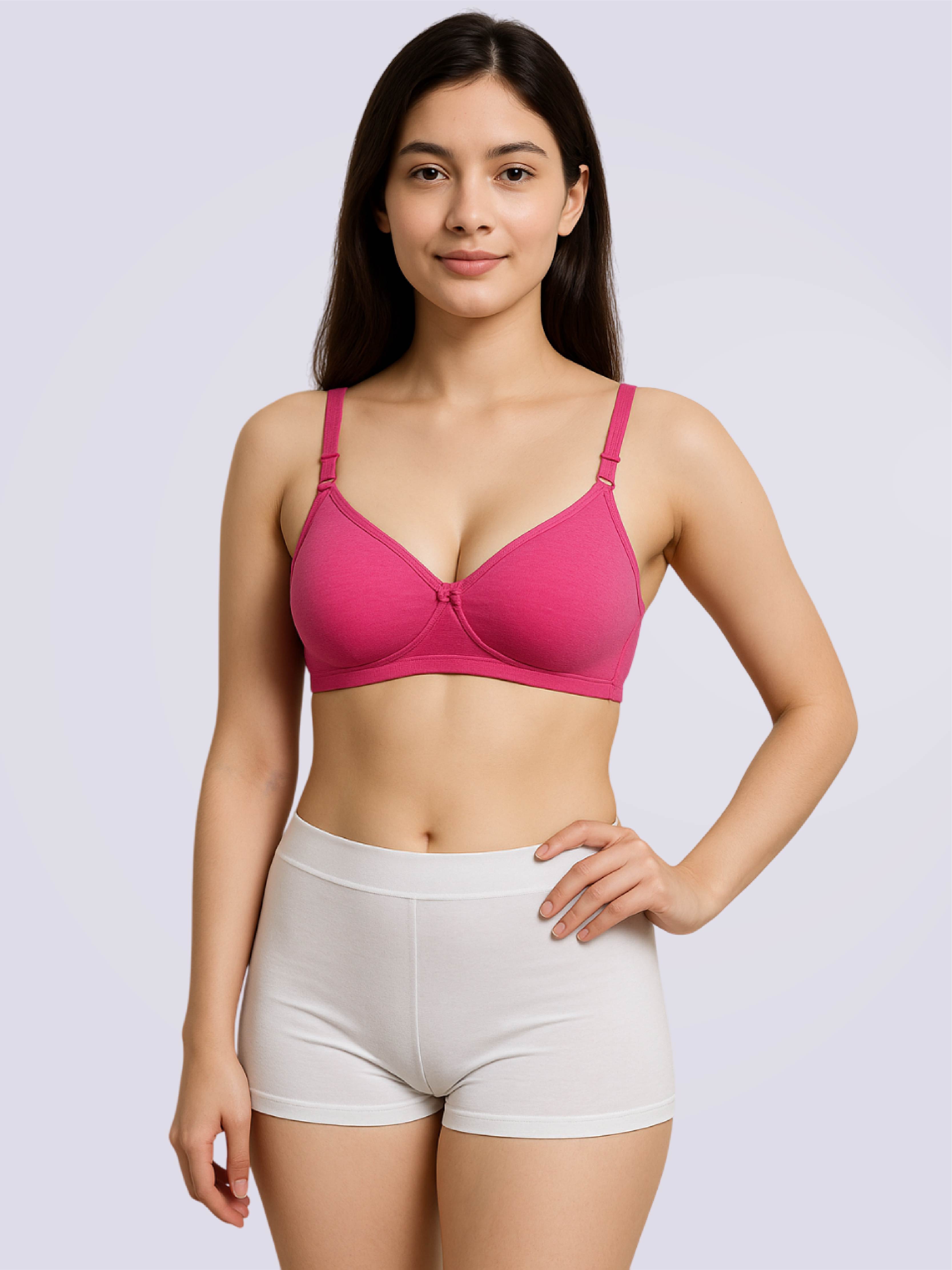 Woman wearing a pink padded bra and white shorts on a light purple background