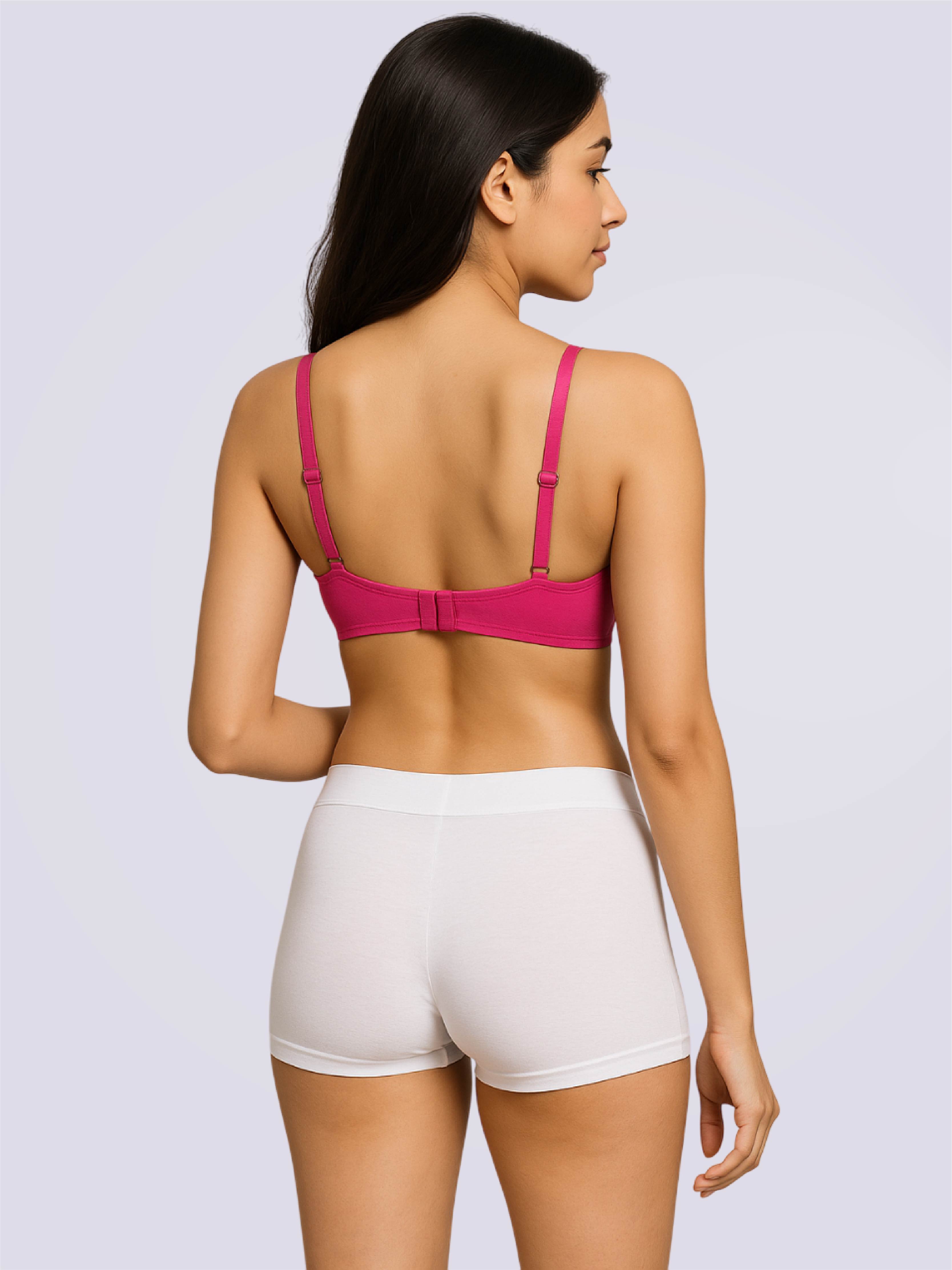 Woman wearing a pink bra and white shorts on a light gray background