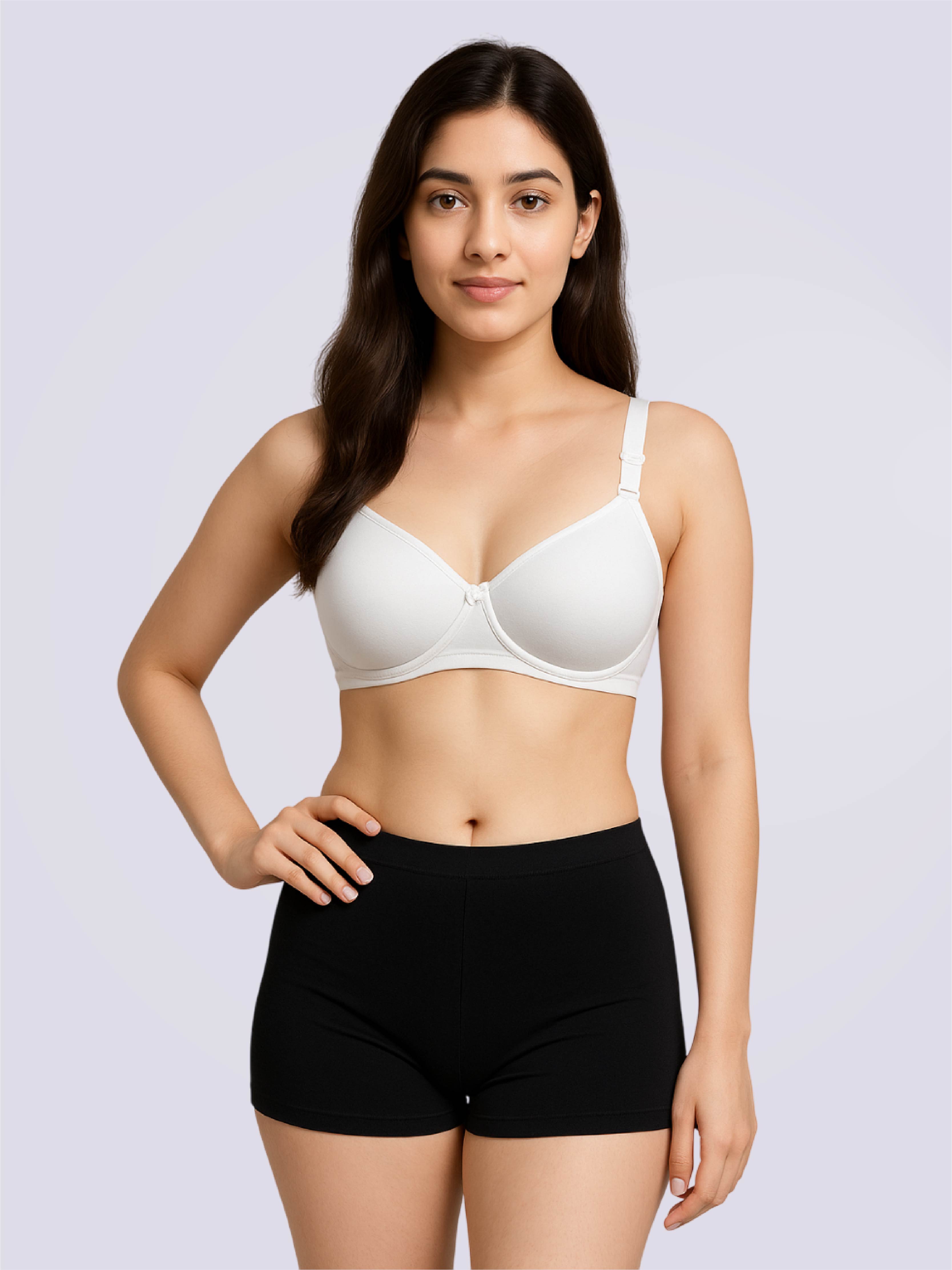 Woman wearing a white bra and black shorts on a light gray background